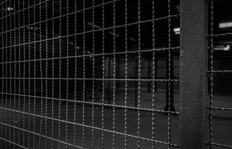 空仓库金属铁丝网 私人区域的深色背景 安全的钢围墙 仓库建筑室内网状围栏 自由概念的障碍 铁丝网和杆链图片