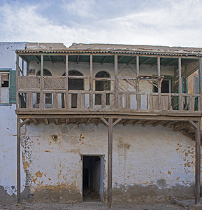 废弃埃及房屋中的旧木建筑外墙乡村石头风化历史蓝色阳台快门窗户房子木头图片