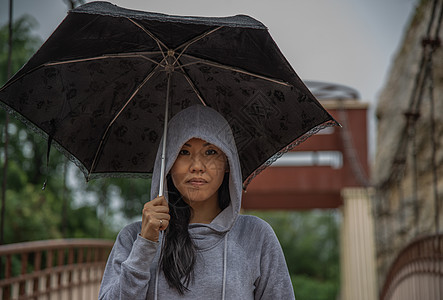 在雨天 年轻的亚洲妇女持有伞状和在木桥上过桥艺术街道女孩城市女性图片