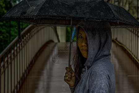 在雨天 年轻的亚洲妇女持有伞状和在木桥上过桥街道艺术女性女孩城市图片
