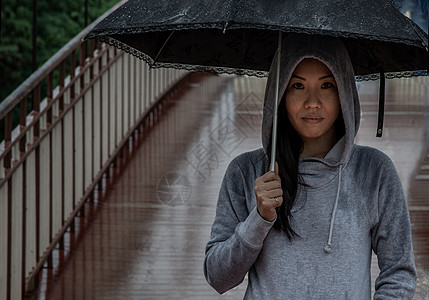 在雨天 年轻的亚洲妇女持有伞状和在木桥上过桥街道女孩艺术女性城市图片