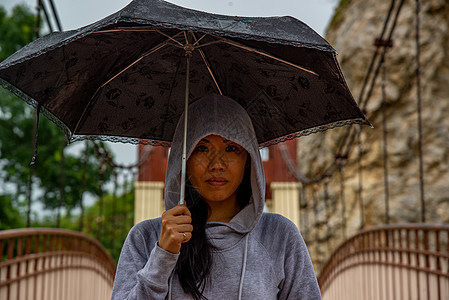 在雨天 年轻的亚洲妇女持有伞状和在木桥上过桥城市艺术女孩女性街道图片