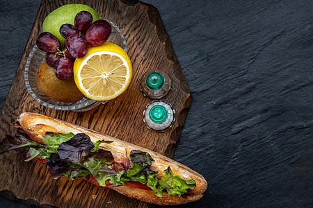 一个美味的熏鲑鱼芝麻面包三明治 木板上还有新鲜水果酵母面粉食物种子早餐烹饪熏制美食面包浆果图片