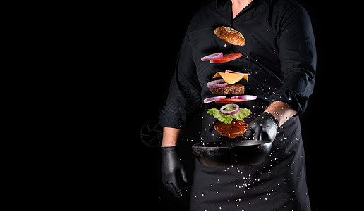身穿黑色制服的男子 拿着一个铁环煎锅 配上起司汉堡原料图片