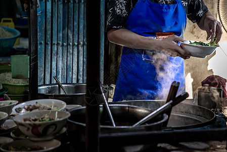 当地餐厅的厨师煮鸡蛋面和烤猪肉 泰国街头食物 在传统亚洲食品中做面条店铺旅行猪肉市场商业制作者烹饪街道城市拉面图片