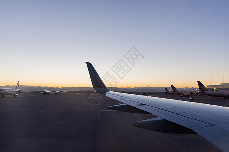 在机场停靠的飞机上空 美丽的黎明蓝天日出运输航空天空旅行车辆航班翅膀日落旅游图片