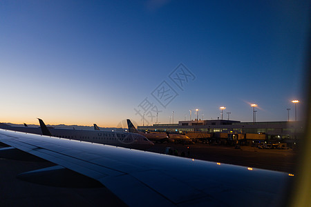 机场航班显示表在机场停靠的飞机上空 美丽的黎明蓝天航班航空公司旅游日落运输商业假期航空空气飞行背景
