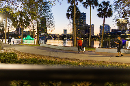 以湖泊和建筑物为背景在公园中行走的人场景运动建筑娱乐景观城市商业旅行跑步灯光图片