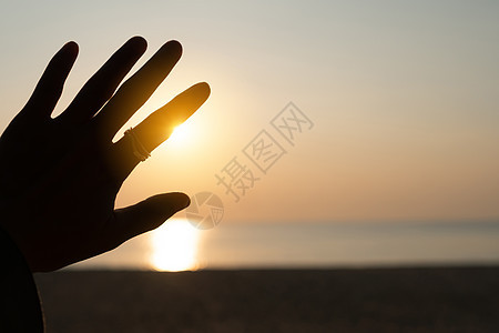 向日落的天空伸出双手 沙滩沙滩自然背景 放松和在假期中休息橙子海洋海滩财富手臂女士生活太阳女孩环境图片