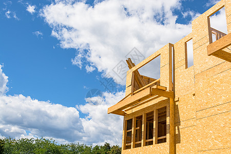 正在以蓝天背景建造的新住宅楼 建筑中的蓝色天空背景住房框架不动产晴天木材村庄邻里木头窗户家庭图片