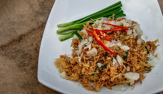 亚洲美食 Mee Grob 是一种糖醋脆皮面 由泰国米粉和白盘糖醋酱制成 Sweet香菜面条蔬菜洋葱蜂蜜食物文化盘子炒面油炸图片