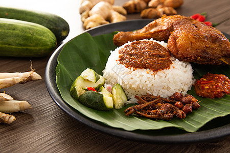 Nasi Kukus通常由新鲜蒸米和脆烤炸鸡组成米饭香料马来语鸡翅美食传统食物蒸汽咖喱汁盘子背景图片