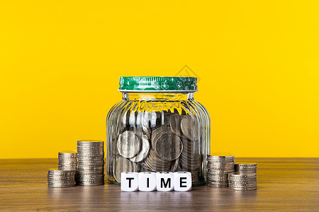 在有黄色背景的玻璃罐中有很多硬币 保存投资概念现金金融生长保险养老金储蓄投资者预算基金兴趣图片