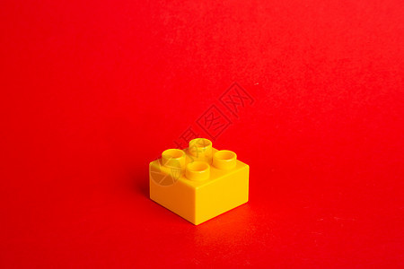 红色背景上的彩色塑料积木建筑物幼儿园游戏童年闲暇乐趣教育蓝色盒子玩具图片