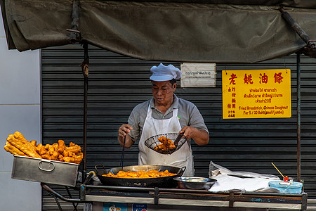 厨师正在用钢锅上的热油炒中国深炸面团食物油条男人小吃烹饪平底锅餐厅营养旅游美食图片