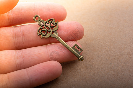 手握旧式装饰键秘密财产自由入口解决方案钥匙商业古董挂锁房子图片