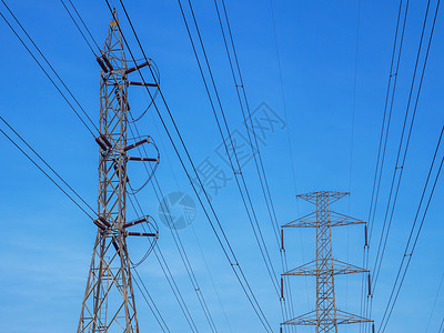 蓝色天空和白云背景上带有电线的高压输电塔的顶部高压发射塔图片