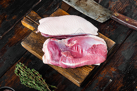 新鲜鸭肉作为食物 生鸭乳 用旧屠宰刀 旧黑木桌底的木板切餐板上图片