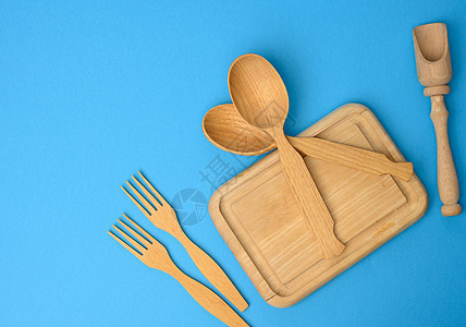 蓝底的木制木制勺 叉和长方形切割板厨具刀具菜单木板食物木头工具烹饪美食工作室图片
