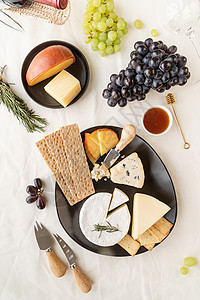 配有蜂蜜 葡萄 面包和迷迭香的奶酪板板类蓝色木板熟食桌子小吃奶制品乡村甜点干酪食物图片