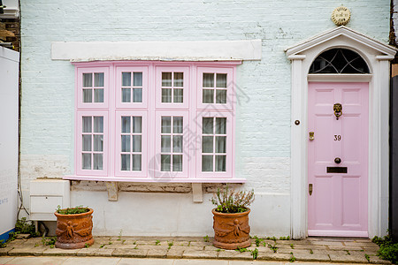 白色和粉红色英国房子的前面一面 外面有锅子图片