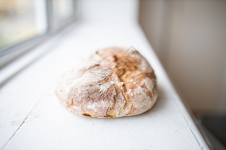 窗边一个白色厨房柜台旁的白厨房柜台上的甜面包甜点脆皮食品工匠午餐糕点焙烤包子饮食食物图片