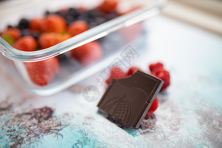 薄饼巧克力条和草莓 在多彩色的地垫上热带水果糖果可可甜点插图零食生活方式容器覆盆子图片