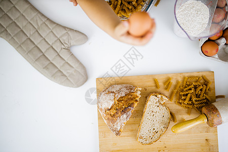 手持鸡蛋高于表上成分的雌性手厨房烹饪桌子木辊化合物碳水饮食小吃面条美食图片