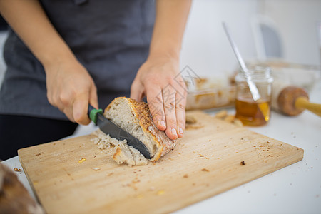 女性用手在切割板上切面包午餐食谱烹饪食物饮食木辊小吃营养砧板小麦图片