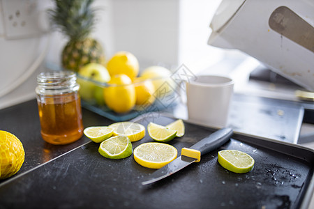柠檬和石灰片放在蜂蜜罐子旁边的托盘上容器菠萝玻璃热带茶壶水果杯子烹饪保温壶准备图片