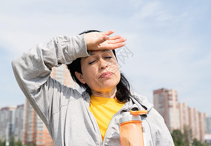 在公园户外辛勤锻炼后 高级女性 排出汗水闲暇力量福利毛巾微笑女士老年摇床运动瓶子图片