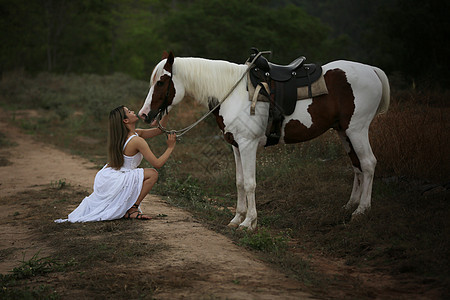 穿着裙子的女性在日落时 在田地风景中骑马对抗天空荒野骑师友谊女孩农场牛仔马术骑术骑士爱好图片