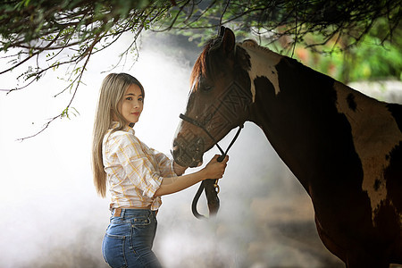 一名身着女牛仔风格的妇女坐在西部农场环境的马场里马术女性宠物动物运动骑士女孩哺乳动物闲暇骑师图片