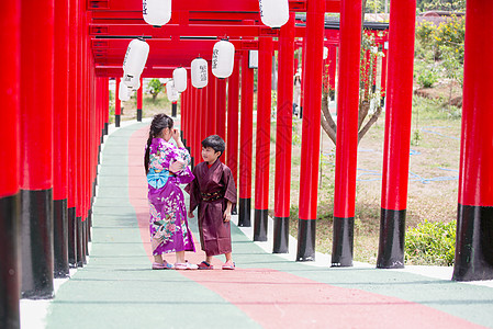 两个和服里的小孩 走进圣殿红门 在日本花园里神社人行道旅游裙子神道隧道小路传统艺妓戏服图片