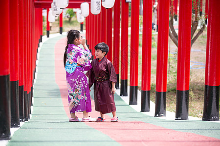 两个和服里的小孩 走进圣殿红门 在日本花园里旅行神道传统人行道隧道女性文化旅游裙子戏服图片