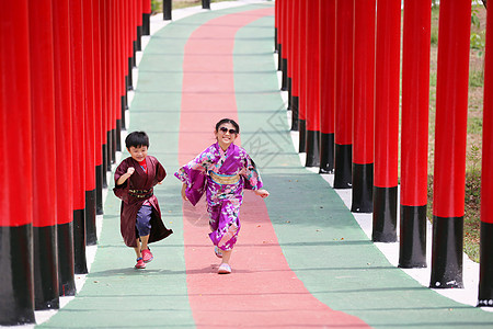 两个和服里的小孩 走进圣殿红门 在日本花园里旅行女士艺妓小路女孩神道寺庙隧道建筑学裙子图片