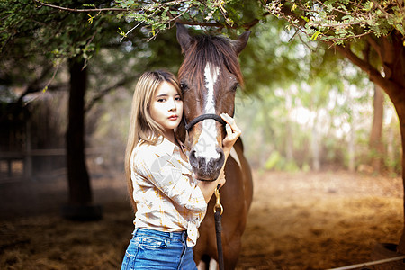 一名身着女牛仔风格的妇女坐在西部农场环境的马场里友谊骑士骑术闲暇荒野哺乳动物草地爱好宠物女孩图片