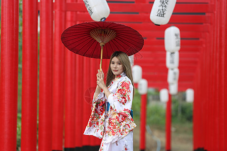 穿着和服的女人拿着伞走进来 在圣殿红门 在日本花园建筑学宗教寺庙女性旅游神社人行道神道文化地标图片