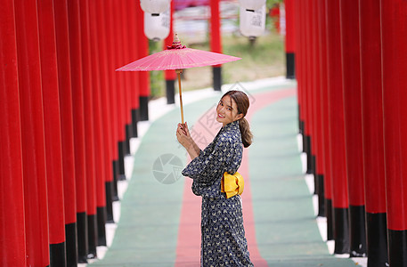 穿着和服的女人拿着伞走进来 在圣殿红门 在日本花园女性女士地标神道寺庙传统旅行建筑学戏服隧道图片