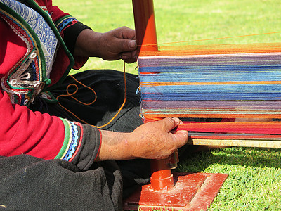身穿正经裙子的秘鲁女士近距离亲近工艺羊毛编织骆驼传统染料细绳手工业旋转工作图片