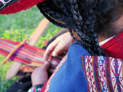 身穿正经裙子的秘鲁女士近距离亲近工艺品细绳产品织工染料骆驼旅行羊毛纺织品旋转图片