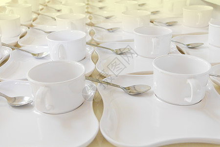 白色咖啡杯排 桌上有碟子和勺子餐厅庆典盘子制品店铺咖啡早餐会议塑料食物图片