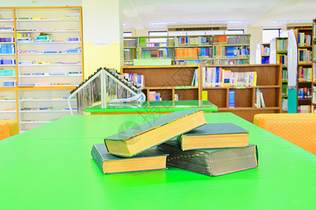 学校图书馆的旧书和堆积专论 放在绿色桌边 模糊的书架背景 教育学习概念与复制空间添加文字历史桌子精装图书管理员诗歌百科大学全书收图片