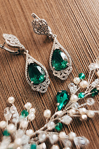 特写耳环 用大块绿石和棕色背景的白珠子装饰图片