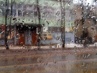 窗玻璃上的雨滴 选择性的焦点 多雨的城市背景图片