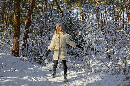 快乐的女人在雪地户外的大自然中行走图片