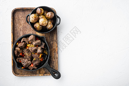 牛肉炖萝卜用牛肉 土豆 胡萝卜和香草做的爱尔兰炖菜 用铸铁煎锅 白石表面 顶视图平躺 有文字复制空间背景