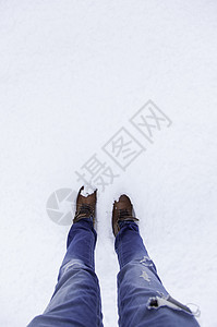 男人的脚在雪地里皮革季节远足鞋类牛仔裤旅行靴子男性女士衣服图片