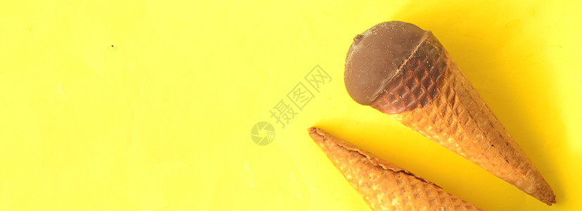 巧克力冰淇淋锥 在阳光明媚的夏季黄色背景背景图片