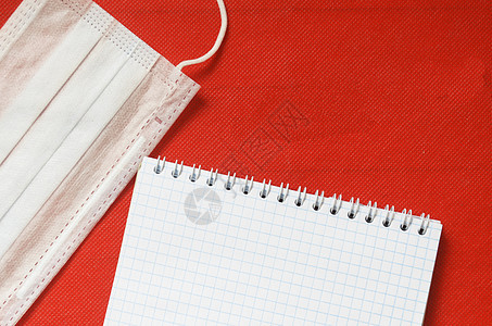 眼部 医疗面具 温度计和红色背景的乳胶笔记本 在红底图片